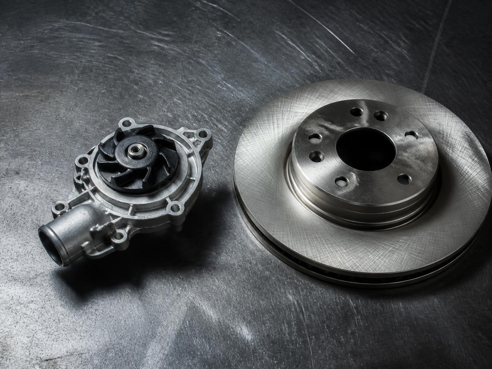 Genuine BMW water pump and brake rotor on a steel workbench